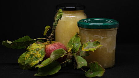 A delicious apple jam in glass jar on black backgroundの写真素材