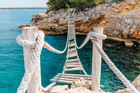 A wooden bridge with steps over the sea with rock formationsの写真素材