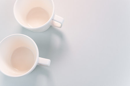 A top view of empty white coffee cups placed on a white surfaceの写真素材