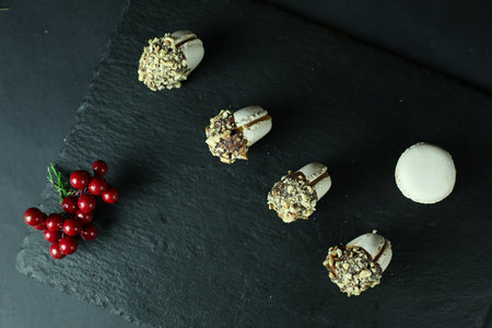 A high angle shot of white macaroons dipped in chocolate with nuts