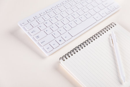 A closeup of a keypad and a notepad with pen on a white table - concept of jobの写真素材