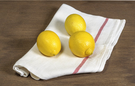 A closeup shot of lemons on a towel on the tableの写真素材