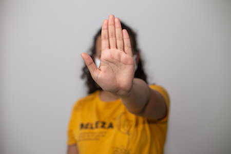 A person holding their hand in front of their face gesturing stopの写真素材