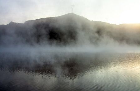 A beautiful shot of a reflective lake during a foggy weatherの写真素材