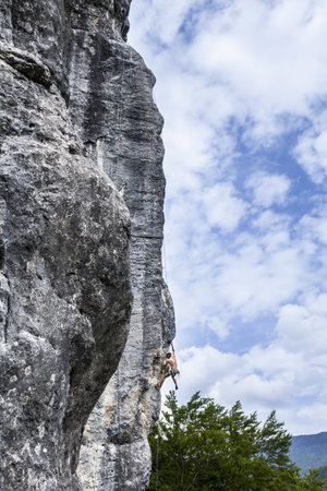A breathtaking shot of a young male climbing on the high rock in  Champfromier, Franceの写真素材