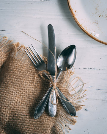 The fork, knife, and spoon tied in a bow on the wooden tableの写真素材