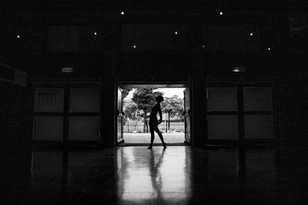 A backlit black and white shot of a ballerina during practice.