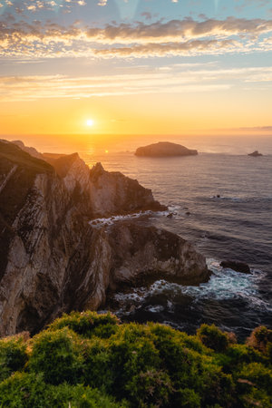 A breathtaking view of the Atlantic ocean coast near Cabo de Penas at sunsetの写真素材