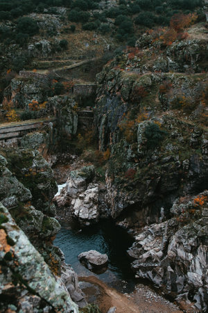 A vertical shot of river surrounded by mossy rocksの写真素材