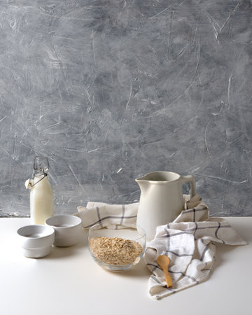An aesthetic view of a milk glass and oats decorated with a piece of fabricの写真素材