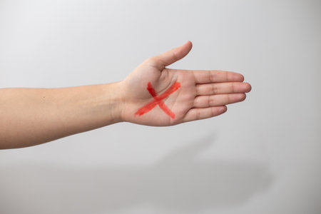 A hand with a red X sign isolated on a white backgroundの写真素材