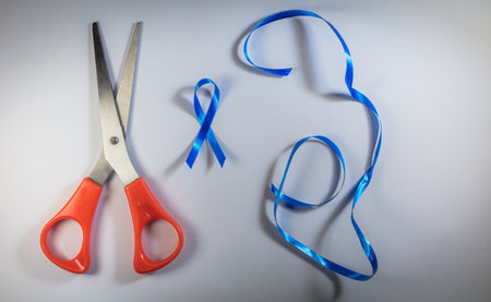 A top view of blue ribbons and scissors for awareness campaigns on male health and prostate cancerの写真素材