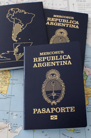 A vertical high angle shot of passports of Argentina on a world map - concept: travelの写真素材