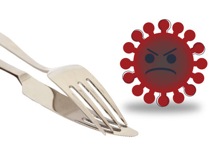 An isolated shot of an angry virus next to a fork and knife on white background