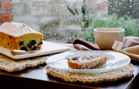A fresh blueberry cake served with fragrant tea on a rainy day, autumnal mood
