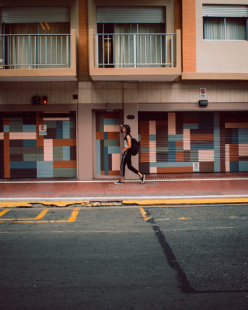 A shot of a young girl with a backpack walking on the street