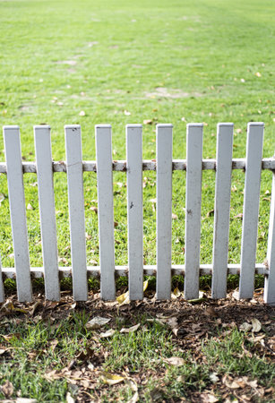 A vertical shot of white wooden fence in the yardの写真素材