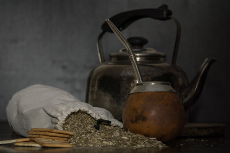 A shot of a brown calabash, a kettle and a bag filled with tea herb called mateの写真素材