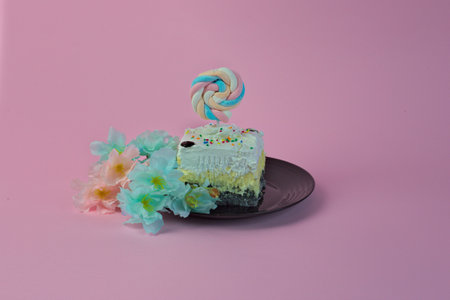 A sweet piece of cake with marshmallows on it and colorful flowers next to itの写真素材
