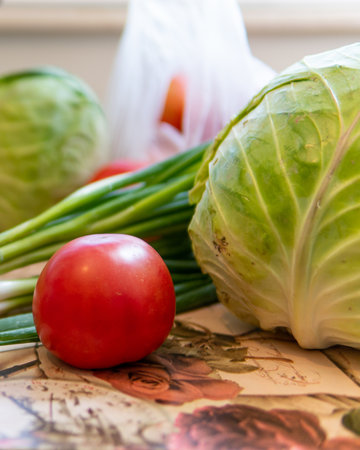A closeup shot of vegetables on the table; tomato, pepper, cabbage, green onion scallionsの写真素材
