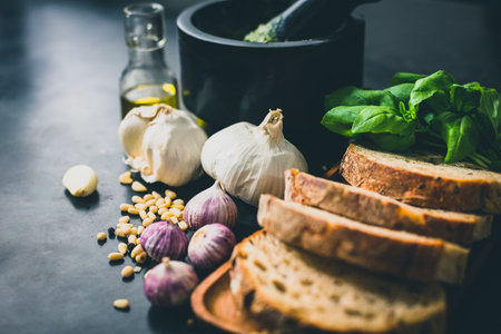 A closeup of bread slices and garlic cloves on the table with a blurry backgroundの写真素材