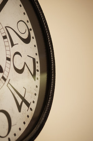 A vertical shot of vintage clock numbers on the beige backgroundの写真素材