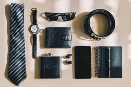 A shot of male objects: watch, tie, belt, cell phone, wallet, notebook, headphones, sunglassesの写真素材