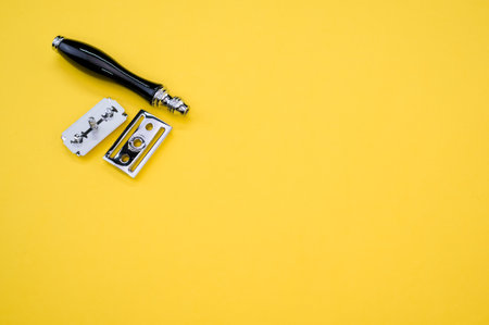 A top view of a mechanical razor and blade isolated on yellow backgroundの写真素材