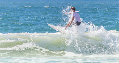 A young man surfing on a sunny day in Brazil