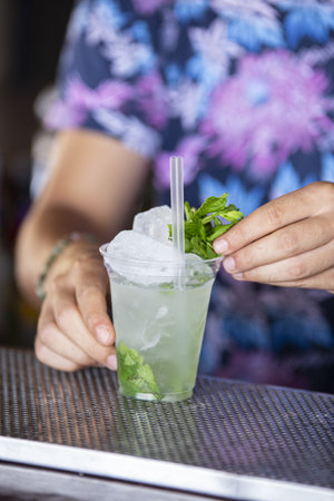 A selective focus shot of a bartender making mojito cocktail on a bar counteの写真素材