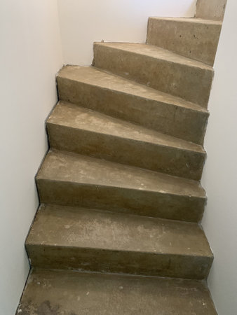 A closeup vertical shot of a concrete spiral staircase during the home renovation process