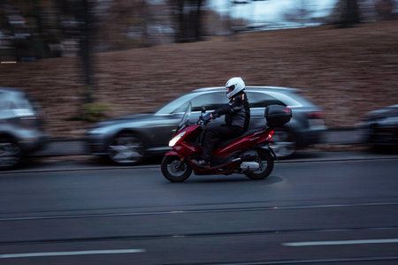 A selective focus shot of a man driving his motorcycle with long exposure