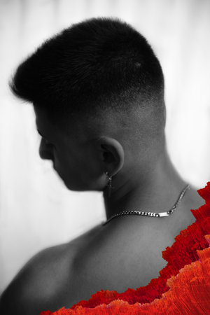 A vertical grayscale shot of a young males neck with a chain and cool red artの写真素材