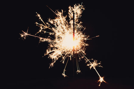 A closeup shot of sparkler with bokeh light isolated on dark backgroundの写真素材