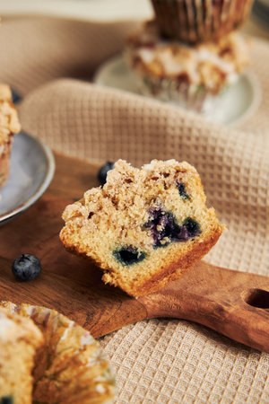 A vertical shot of delicious vegan blueberry muffins on a decorated tableの写真素材