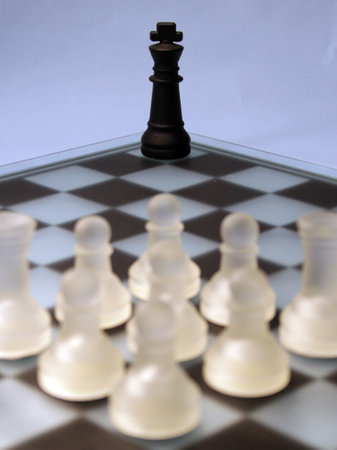 A vertical shot of the black king figures against the white pawnsの写真素材