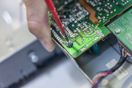 A closeup shot of a persons hand working on a motherboard