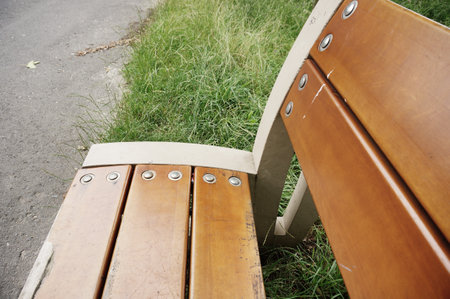 A closeup shot of a wooden bench in a park