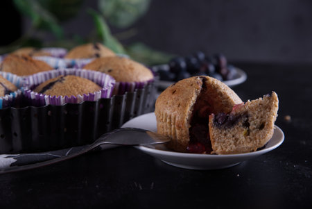 A selective focus closeup of the Blueberry muffins on a wooden cutting boardの写真素材