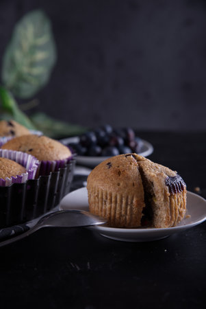 A selective focus closeup of the Blueberry muffins on a wooden cutting boardの写真素材
