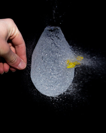 A closeup shot of a popped balloon full of waterの写真素材