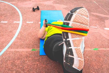 A shallow focus shot of an overweight female with expander during her workoutの写真素材