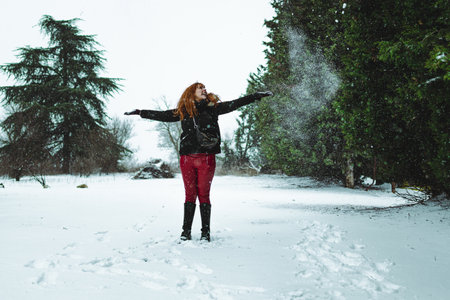 A closeup of a happy woman playing with snow