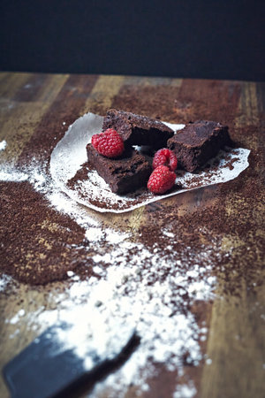 A selective focus shot of homemade chocolate brownie dessert with raspberriesの写真素材