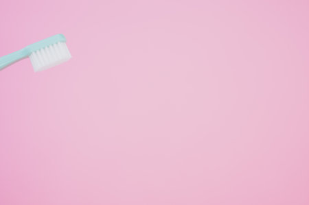 A closeup of a clean toothbrush isolated on a pink backgroundの写真素材