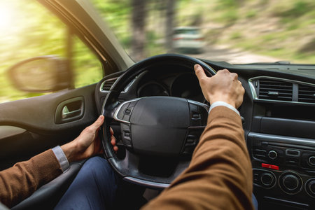 A man driving a car with a black leather cabin during the daytime