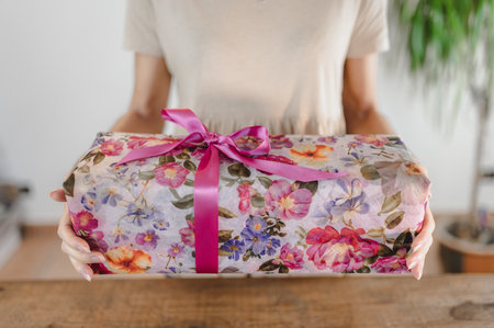 A woman holding a beautifully wrapped gift box