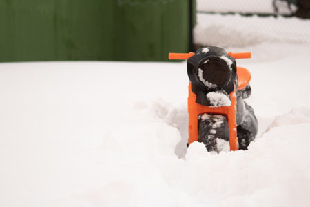 A selective focus shot of a black and orange sled in the snowの写真素材