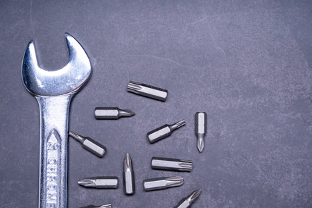 A top view of a wrench with bits on gray background