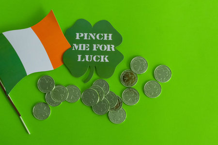 A Saint Patrick's Day banner with the Irish flag, cloverleaf, and golden coins on a green backgroundの写真素材